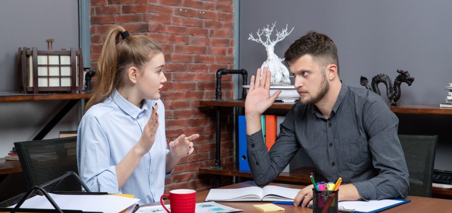 top-view-young-man-female-co-worker-discussing-one-issue-office-enviroment